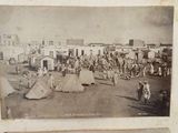 two old black and white photos of people and tents in a town