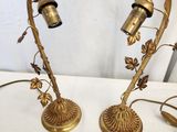 pair of brass table lamps with flowers and leaves on them
