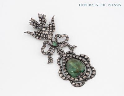 an image of a broochle with a green stone surrounded by diamonds