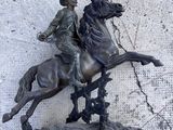 une statue représentant un homme à cheval, coiffé d'un chapeau