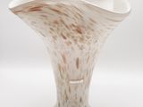 un vase blanc et marron posé sur une surface blanche