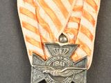 un ruban rayé orange et blanc orné d'une croix argentée