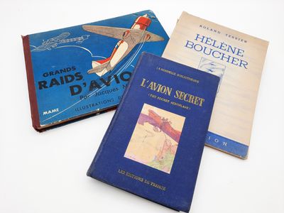 Trois livres sont posés sur une surface blanche ; l'un est un avion et l'autre est un livre.