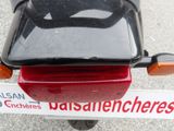 a red motorcycle parked in a parking lot with a sticker on the back of it