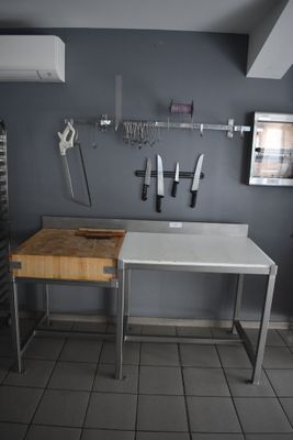 une cuisine équipée d'un évier, d'une planche à découper et d'autres ustensiles de cuisine accrochés au mur