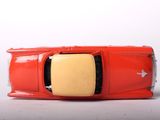 a red toy car that is sitting on a white surface