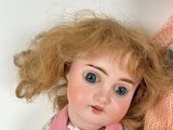 a doll that is laying next to a stuffed animal