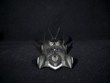a small metal bug that is sitting on a black surface