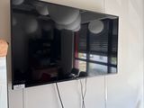 une télévision à écran plat fixée au mur au-dessus de deux fauteuils
