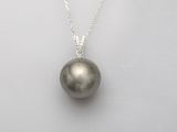 un pendentif en perle noire monté sur une chaîne en argent