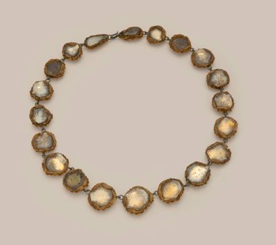 a gold and silver necklace with oval shaped stones