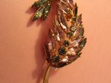 une broche dorée et verte ornée d'une feuille