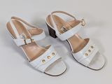 a pair of white sandals with gold buckles on them