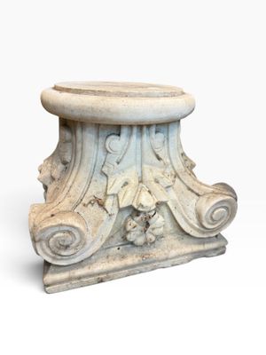 an image of a white marble pedestal with carvings on it