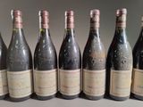six bottles of wine are lined up in a row on a table