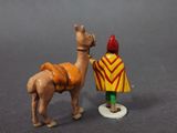 toy figurine of a camel and a man with a red hat