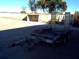 a trailer with a ladder attached to it in a parking lot