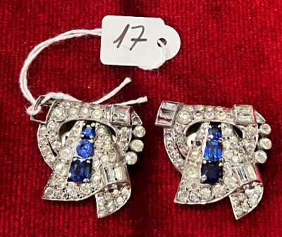 une paire de boucles d'oreilles en diamant bleues et blanches, avec une étiquette de prix posée sur un morceau de tissu rouge