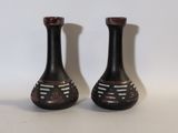deux vases noirs posés l'un à côté de l'autre sur une table