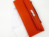 wallet on a white table with a notepad and a pen