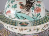 a white and blue vase with a bird on top of it