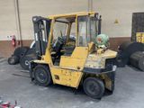 a yellow forklift truck parked in a parking lot