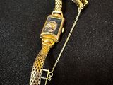 a close up of a watch on a chain on a black surface