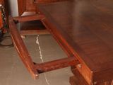a wooden table with a drawer underneath it in a room