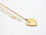 a gold heart locke necklace with a diamond on a chain