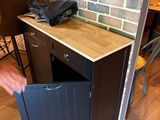 un homme qui ouvre une petite armoire dans un coin d'une pièce