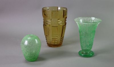 three different colored glass vases sitting next to each other