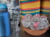 a basket of plastic cups on a counter next to a blue water bottle