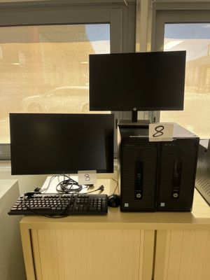 two computer monitors and a keyboard on a desk