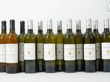 plusieurs bouteilles de vin sont alignées sur une surface blanche