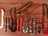 a close up of a bunch of necklaces on a wooden table