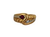 gros plan d'une bague en or avec une pierre en rubis