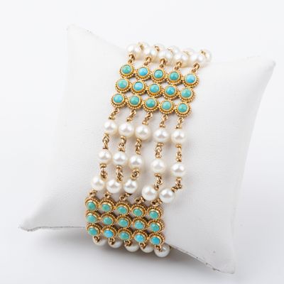 Gros plan sur un bracelet posé sur un coussin, sur une surface blanche