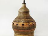 une image représentant un vase marron et noir percé de trous