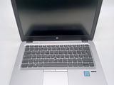 a silver laptop computer sitting on a white surface