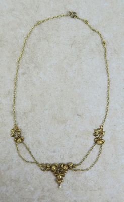 gros plan d'un collier en or sur une surface blanche