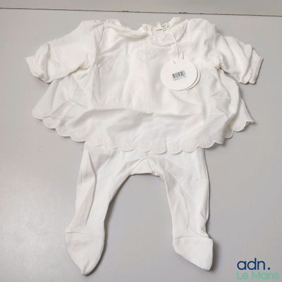 baby clothes on a white table with a tag on it