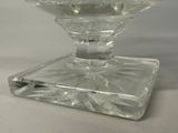 a clear glass candle holder on a white table