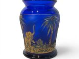a blue vase with an elephant and palm trees on it