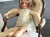 a doll that is sitting in a chair on the floor