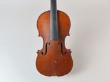 un vieux violon posé sur une surface blanche