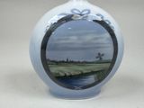 a vase with a picture of a golf course painted on it