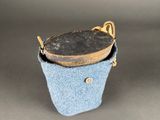 blue felt bucket with a wooden handle on a gray background
