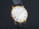 gros plan d'une montre-bracelet en or avec des chiffres romains