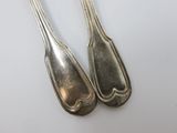 pair of silver plated spoons on a white surface