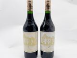 deux bouteilles de vin posées l'une à côté de l'autre sur une surface blanche